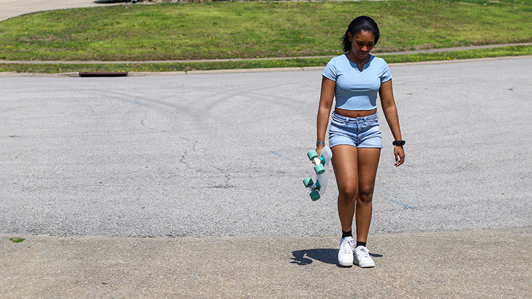 Teenager holding a skateboard.
