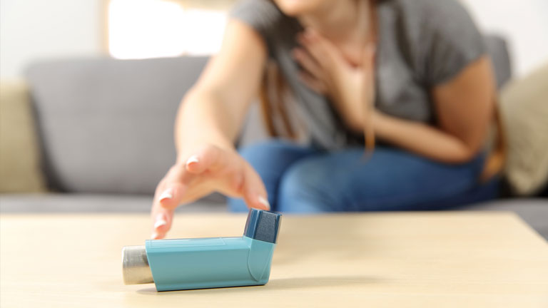 A girl reaches for her inhaler